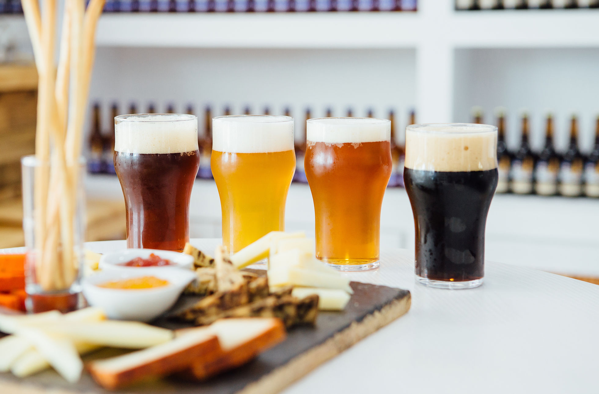 A flight of four San Diego craft beers served with cheese and snacks